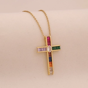 Close-up of gold cross pendant necklace featuring colorful inlaid zircon gemstones