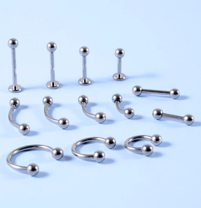 Collection of silver G23 titanium body piercing jewelry in various sizes and shapes