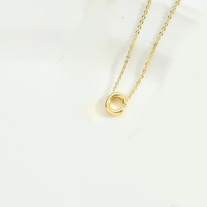Close-up of minimalist golden letter C pendant on delicate link chain necklace