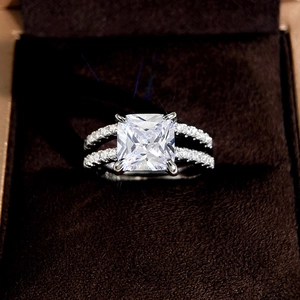 Macro shot of princess cut square diamond ring with side stones on dark velvet
