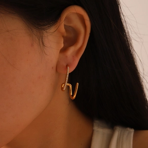 Detail showing irregular 18K gold-plated earring with small white zircons on model
