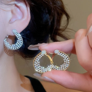 Gros plan d'élégantes boucles d'oreilles fleurs en plaqué or 18 carats et argent et zircon