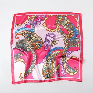 Dettaglio del foulard in raso rosa con motivo paisley e lussuosa texture effetto seta