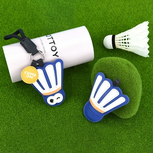 Creative badminton shuttlecock leather keychain with silver ring and yellow tag on green grass