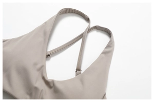 Dettaglio del reggiseno sportivo taupe con spalline incrociate regolabili e tessuto opaco