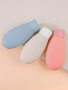 Soft matte silicone travel bottles set in pastel blue, cream, and pink with bow details
