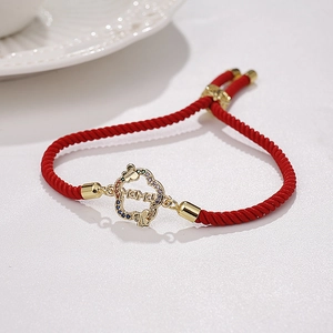 Dettaglio macro del bracciale MAMA rosso con farfalla dorata e zirconi per la festa della mamma