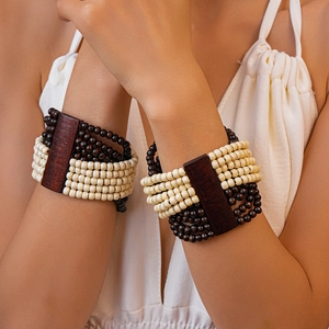 Détail d'un bracelet bohème multicouche avec perles en bois et bloc de bois rouge