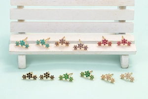 Macro shot of curved floral stud earrings set with six colorful zircons and gold plating