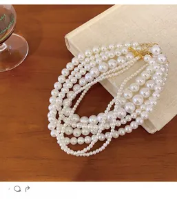 Detail of layered French vintage pearl necklace on a rustic book and wooden background