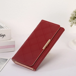 Detailed close-up of wine red quilted faux leather wallet with elegant gold metal trim