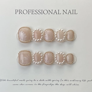 Handmade press-on nails with lily of the valley and pearl accents on a nude pink base