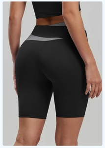 Detail of high-waisted black and gray patchwork yoga shorts showing stretch fabric