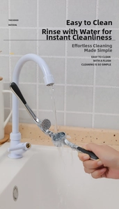 Close-up of cleaning a stainless steel garlic press under running water in a kitchen sink