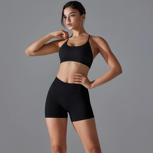 Close-up of black seamless ribbed sports bra and high-waist shorts set on a fitness model