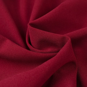 Macro shot of dark red mesh fabric texture with fine grain and elegant draping