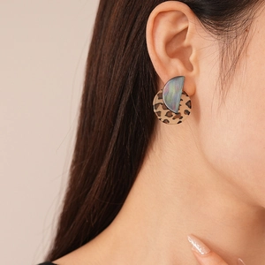 Detail of vintage leopard acrylic earrings with iridescent holographic metallic finish