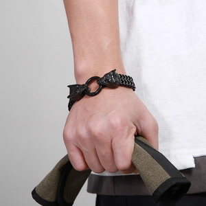 Close-up of black braided titanium steel bracelet featuring double wolf head clasp design