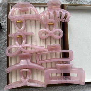 Detail view of 8 pink jelly color hair claws in various shapes within a display box