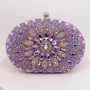 Close-up of luxury purple rhinestone clutch bag with central crystal floral design