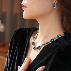 Parure vintage avec pierres ovales bleues et métal doré portée par un mannequin