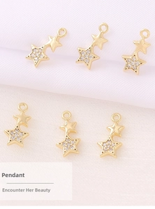 Close-up of six gold star pendants with white cubic zirconia inlay for DIY jewelry