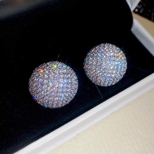 Vue macro de boucles d'oreilles boules pavées de zircons sur velours noir