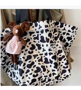 Dettaglio della borsa tote in tela con stampa mucca e ciondolo a forma di topo di peluche