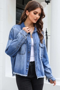 Close-up of distressed denim jacket with fringe hem and vintage washed finish