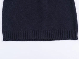Detail shot of the ribbed hem and soft knit texture on this dark blue vintage sweater