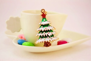 Close-up of sparkling Christmas tree keychain with colorful rhinestones on a gold frame