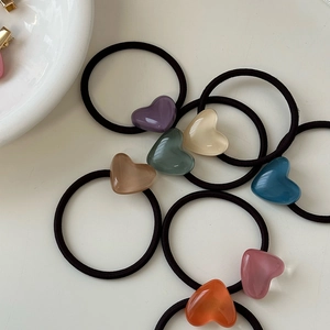Macro detail of assorted jelly-colored heart charms on high-elastic black hair ties