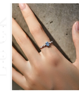 Macro detail of silver crown ring with blue oval gemstone and marquise side stones