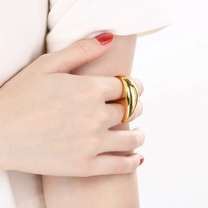 Macro-opname van een minimalistische 18K vergulde roestvrijstalen ring met vloeibaar design