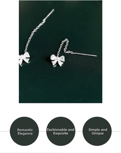 Detailed macro view of S925 sterling silver bowknot earrings with elegant long tassels