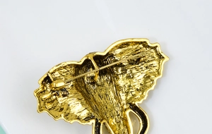 Détail de l'arrière de la broche éléphant dorée avec texture métal et épingle de sûreté