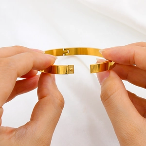 Minimalist oval stainless steel gold bangle with hinged clasp mechanism demo