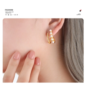 Double-layered gold titanium steel earrings with pearls and crystals shown on model