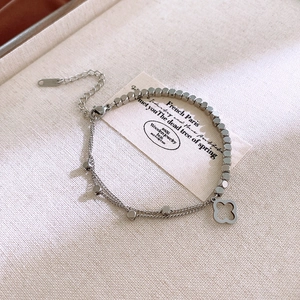 Detail of silver double-layered bracelet with clover charm and S925 engraved clasp