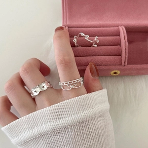 Élégant ensemble de bagues en argent 925 avec cœur évidé présenté sur main avec boîte rose