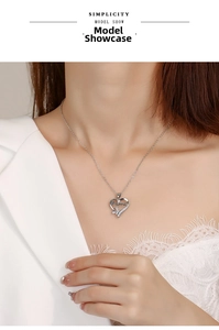 Detail view of heart-shaped Mama necklace with diamond butterfly on a female model