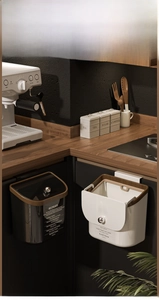 Detail of hanging kitchen bins with walnut wood trim and silver spherical handles