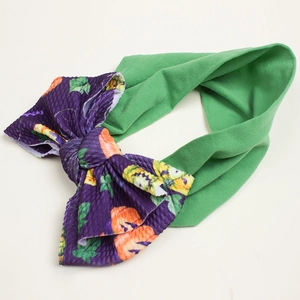 Dettaglio fascia Halloween per neonati con banda verde e fiocco con zucca viola