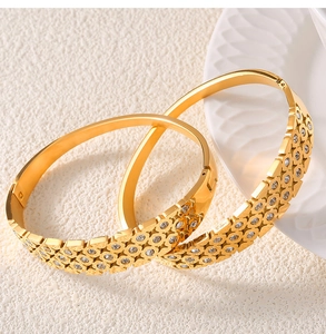 Detailed close-up of gold-plated hollow geometric bracelet with sparkling crystals