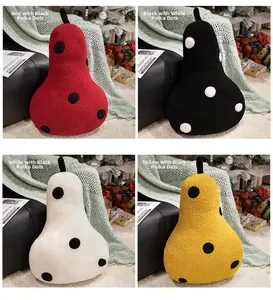 Detailed view of four colorful polka dot pear plush pillows in a cozy holiday setting