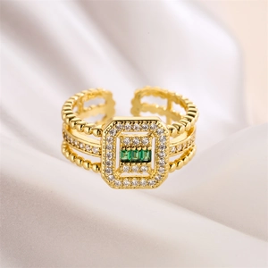 Macro detail of vintage gold-plated ring featuring three emerald-cut green stones
