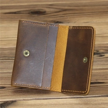 Detailed view of genuine crazy horse leather wallet with brown stitching and snap closure