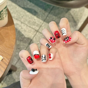 Gothic punk style press-on nails with red and black spider web patterns and 3D pearls