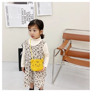 Detail showing plush yellow tiger-shaped children's bag with fine embroidery and soft texture
