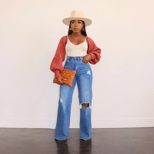 Modische High-Waist Wide-Leg Jeans mit Rissen, roter Strickjacke und Accessoires